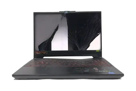 Uszkodzony czarny ekran w laptopie, pęknięty na pół, z widocznymi pęknięciami i fragmentami białego tła.