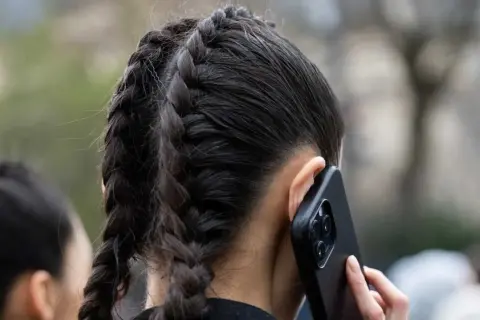 Zwei geflochtene Zöpfe, die wie ein Pferdeschwanz aussehen, sind im Bild zu sehen. Diese pferdeschwanz zopf frisuren sind sehr praktisch.