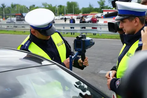 Policjant mierzy prędkość. Kierowca przekroczył prędkość o 30 km/h.