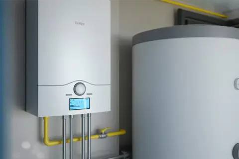 Nowoczesny kocioł jednofunkcyjny lub dwufunkcyjny obok zasobnika wody. Instalacja grzewcza gotowa do pracy.