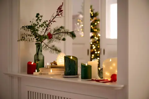 Gemütliche weihnachtsdeko tipps: Kerzen, Tannenzweige und Lichterketten schaffen festliche Stimmung.