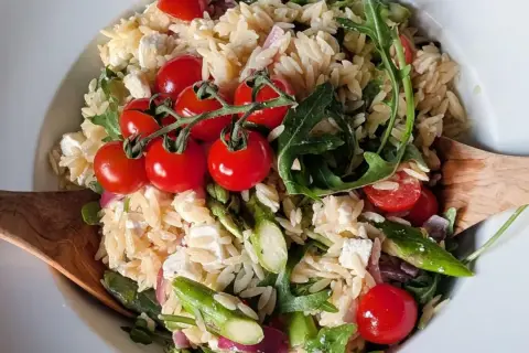 Leckerer Nudelsalat mit Spargel, Kirschtomaten, Feta und Rucola. Ein frischer Genuss!