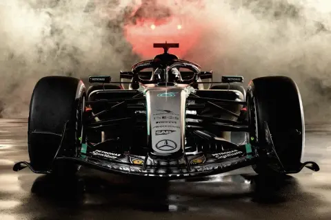 Ein Mercedes Formel 1 Auto in voller Pracht, umgeben von Nebel und rotem Licht. Die **Mercedes Lackierung Kosten** sind hoch, aber das Ergebnis ist atemberaubend.