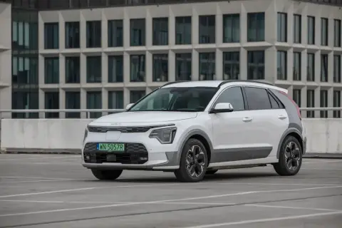 Białe Kia Niro stoi na parkingu. Sprawdź kia niro wymiary, by poznać jego kompaktowe gabaryty idealne do miasta.