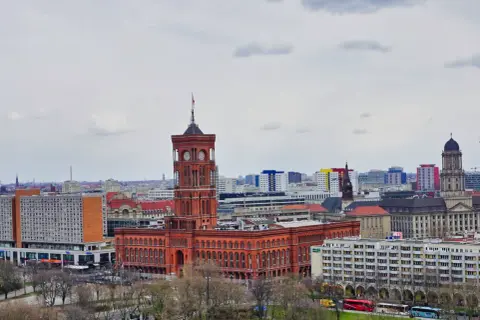 Das Rote Rathaus Berlin, ein imposantes Backsteingebäude mit Turm, dominiert die Stadtsilhouette.