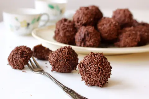 Chokladbollar, perfekta för ett arraksbollar recept. En gaffel ligger bredvid en av de chokladöverdragna godsakerna.