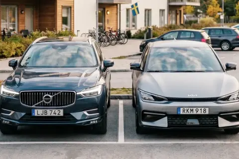 Två elbilar, en Volvo och en Kia, parkerade framför ett modernt hus. Kanske redo för en resa med klimatbonus elbil.