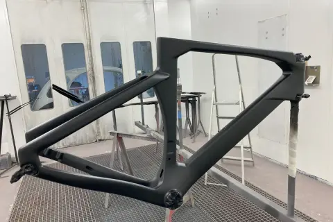 Telaio di bici in carbonio pronto per verniciare, in cabina di verniciatura.