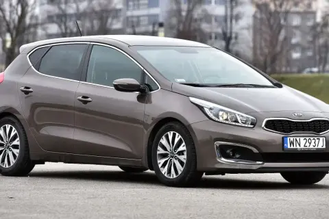 Brązowy Kia Ceed 1.6 benzyna z polskimi tablicami rejestracyjnymi WN 2937J zaparkowany na zewnątrz.