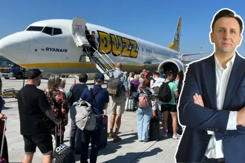 Ryanair Buzz samolot, pasażerowie z bagażem czekają na wejście. Słońce świeci.