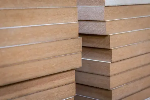Staplade skivor av obehandlad MDF, redo att måla. Perfekt för gör-det-själv-projekt.