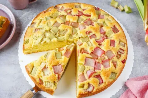 Ein saftiger Rhabarberkuchen, der aussieht wie der beste Rhabarberkuchen. Mit vielen roten und grünen Rhabarberstücken.