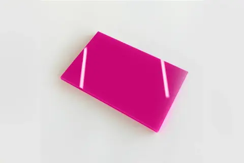 Plaque de plexiglas coloré rose vif, reflétant la lumière.