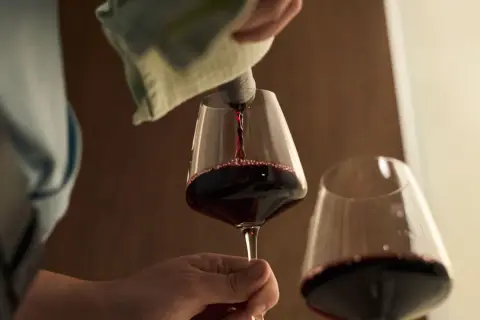 Czerwone wino nalewane do kieliszka. Czy wino jest zdrowe? Debata trwa, ale kieliszek w dłoni wygląda kusząco.