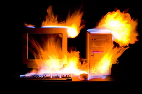 Płonący komputer z lat 2000. i klawiatura, jakby przegrzewały się od emocjonujących, **stare gry na PC lata 2000.**