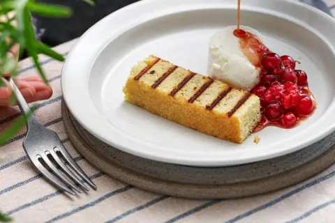 Grillad sockerkaka med vaniljglass, rårörda lingon och en sirap som påminner om ett kardemumma recept.