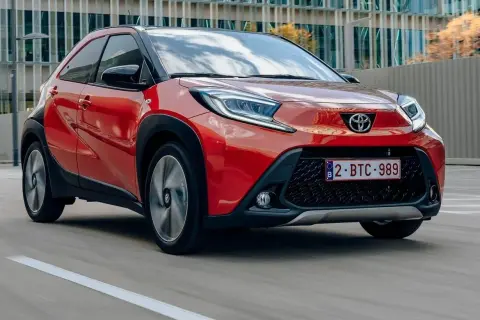Czerwony Toyota Aygo w ruchu miejskim. Wiele osób szuka toyota aygo opinie, by poznać ten model.