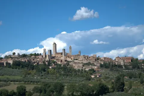 San Gimignano mit seinen Türmen, umgeben von Olivenhainen. Entdecken Sie die Geheimtipps dieser toskanischen Stadt.