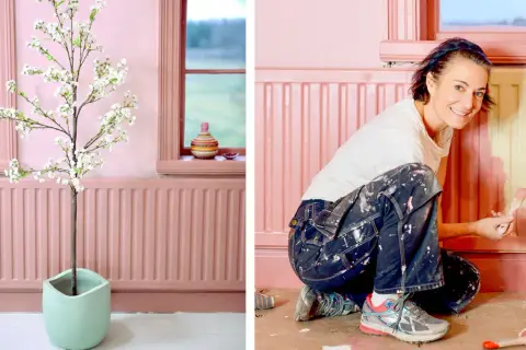 En kvinna målar ett element rosa. En konstgjord blommande körsbärsgren står i en ljusgrön kruka.
