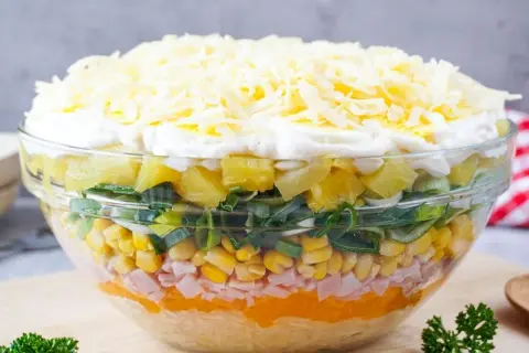 Bunter Schichtsalat mit Ananas, Mais, Schinken und Käse. Ein tolles Beispiel für Schichtsalat Rezepte, das Appetit macht.