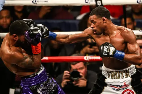 A boxer lands a powerful punch, while his opponent attempts to block with a jab. The intensity of the jab vs punch is palpable.