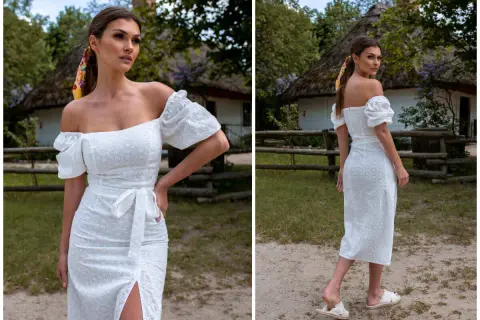 Kobieta w białej, ażurowej sukience z odkrytymi ramionami, w stylu, który przypomina, jak wyglądają hiszpanki.