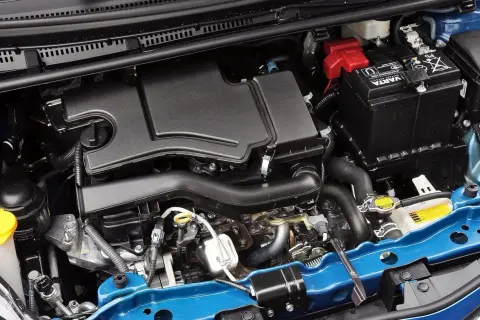 Silnik Toyoty Yaris 2017: czarny plastikowy osłona, akumulator Varta, niebieska belka.