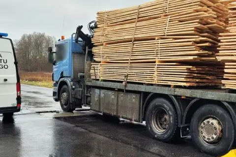 Samochód Inspekcji Transportu Drogowego obok ciężarówki z drewnem.