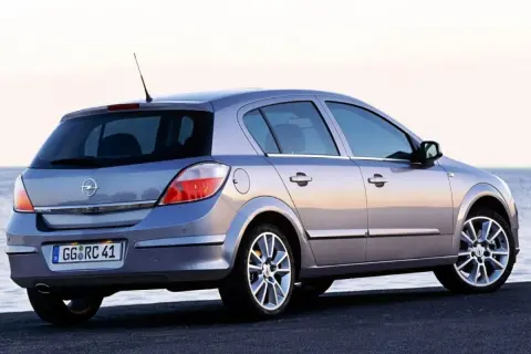 Srebrny Opel Astra H 1.6 benzyna z widokiem z tyłu, zaparkowany nad morzem.
