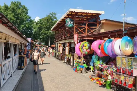 Skorzęcin atrakcje: kolorowe koła do pływania, zabawki i budki z grami na deptaku. Słoneczny dzień zachęca do spacerów.
