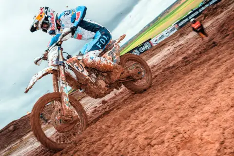 Motocyklista w błocie podczas wyścigu motocrossowego.