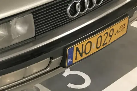 Złota tablica rejestracyjna z numerem NO 029 na zderzaku Audi.