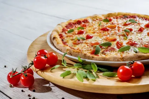 Szukasz miejsca, gdzie dobrze i tanio zjeść w Mikołajkach? Ta pyszna pizza z pomidorkami i bazylią to idealna propozycja!