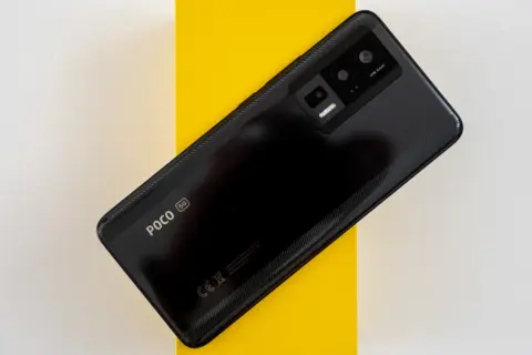 Teléfono negro con módulo de cámara triple y logo POCO 5G. El sensor de proximidad Xiaomi es parte de su avanzada tecnología.