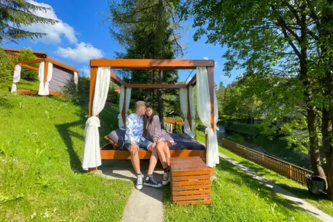 Para zakochanych cieszy się romantycznym wyjazdem na weekend pod baldachimem, otoczona zielenią i strumykiem.
