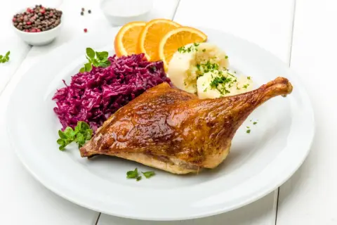 Pieczona kaczka z purée, czerwoną kapustą i pomarańczą. Marynata do kaczki nadała jej apetyczny, złocisty kolor.