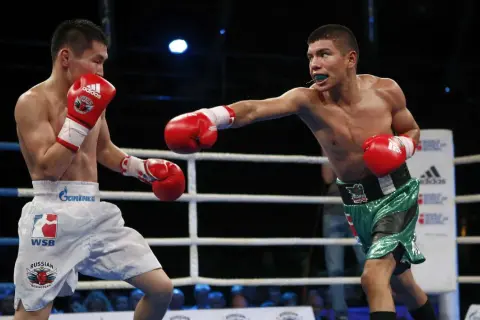 Two boxers exchange blows, showcasing advanced boxing techniques. One fighter throws a jab while the other defends, both wearing red gloves.