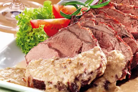 Saftiger Sauerbraten, in Scheiben geschnitten, mit cremiger Sauce und Beilagen. Perfekt für ein langes Schmoren, damit 1 kg Sauerbraten zart wird.