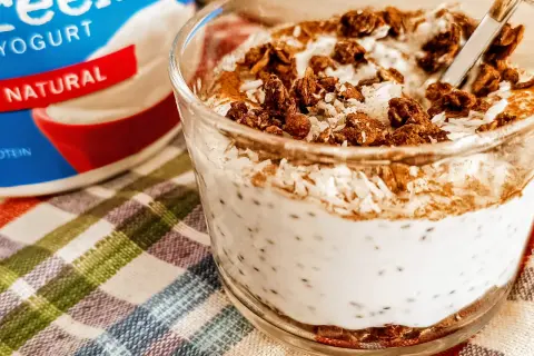 Yogurt greco naturale con semi di chia, cocco grattugiato e granola croccante. Un delizioso e salutare spuntino.