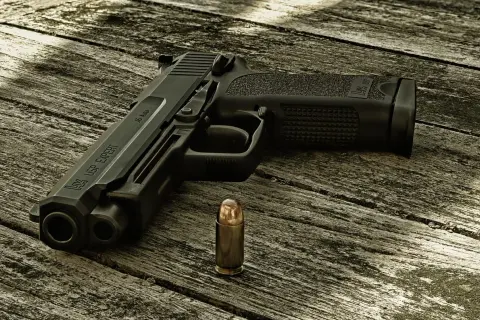 Pistolet HK USP EXPERT z widocznym napisem "45 Auto" obok pocisku. Kaliber pocisku jest kluczowy dla tego modelu.