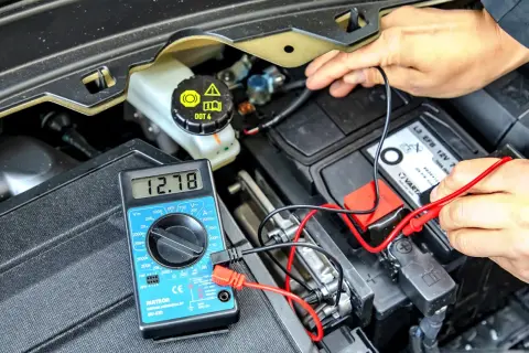 Pomiar napięcia akumulatora multimetrem. Sprawdzanie, ile trwa odsiarczanie akumulatora, to kluczowy etap diagnostyki.