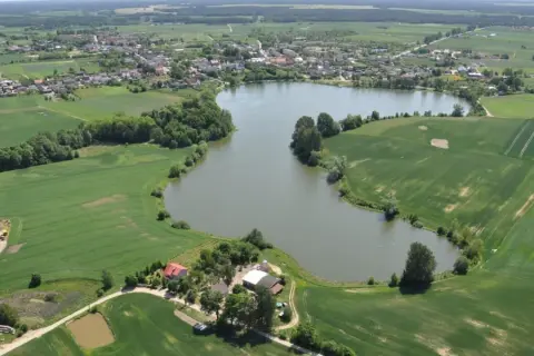 Widok z lotu ptaka na jezioro, pola uprawne i zabudowania w Przechlewie.