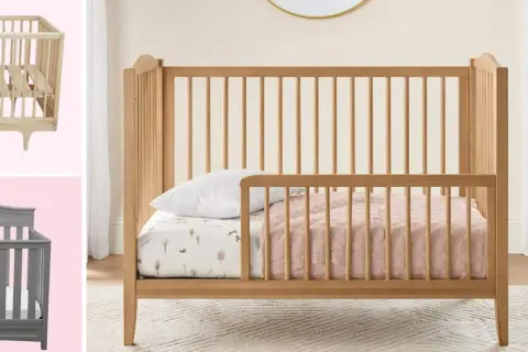 A wooden toddler bed with rails is shown, perfect for what kind of bed should a 2 year old be in. A grey crib is also visible.