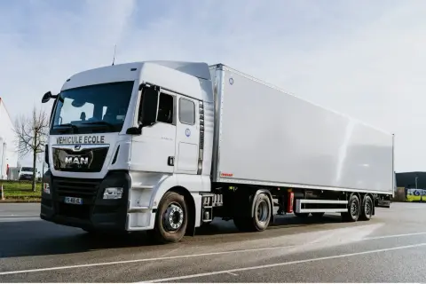 Camion blanc "Véhicule École" pour apprendre le permis poids lourd. Il est prêt pour la formation.