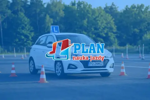 Biały samochód z literą "L" na dachu i logo "PLAN nauka jazdy" na tle drzew i pachołków. Idealny do nauki, jak przygotować się do jazdy na egzaminie.