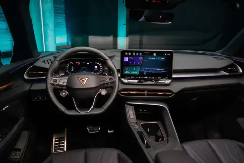 Interni moderni e tecnologici della Cupra Terramar, con ampio display centrale, volante sportivo e illuminazione d'ambiente.