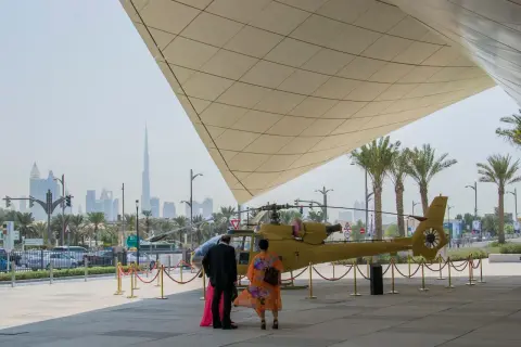 Luksusowe dubaj wczasy: ludzie podziwiają helikopter na tle drapaczy chmur.