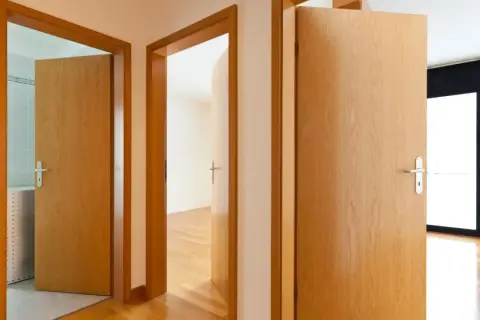 Pasillos con puertas de madera clara. Aprende como limpiar puertas de contrachapado para mantenerlas así de relucientes.