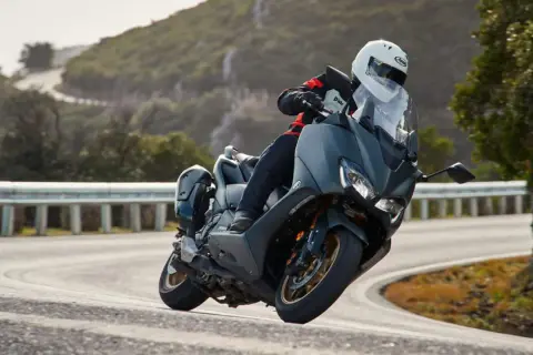 Motociclista en TMAX, disfrutando de la velocidad máxima en una carretera sinuosa.