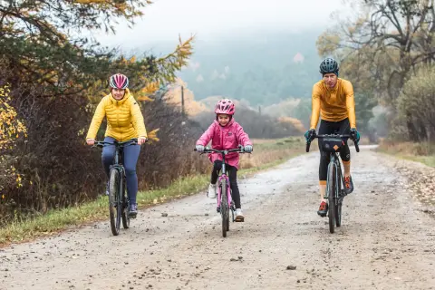 Rodzina na rowerach przemierza malowniczą dolinę Wisłoki jesienią.